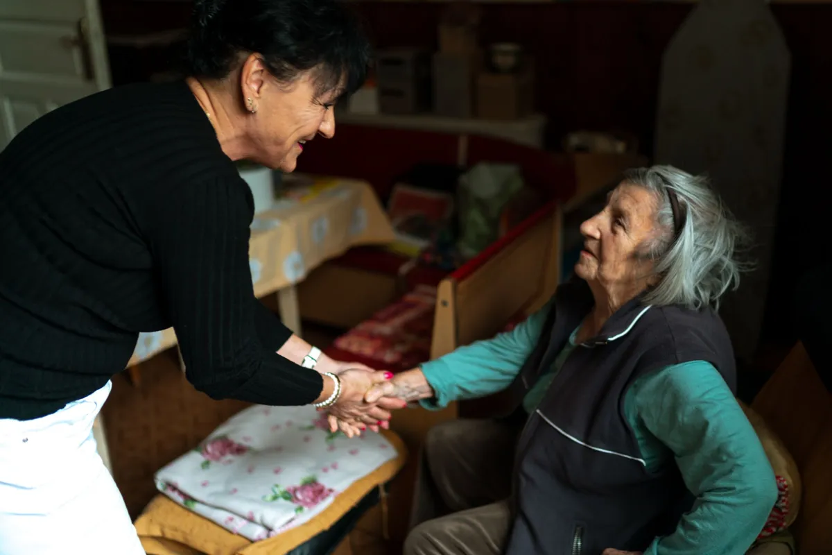 Rencontre chaleureuse entre une accompagnante et une femme âgée à son domicile